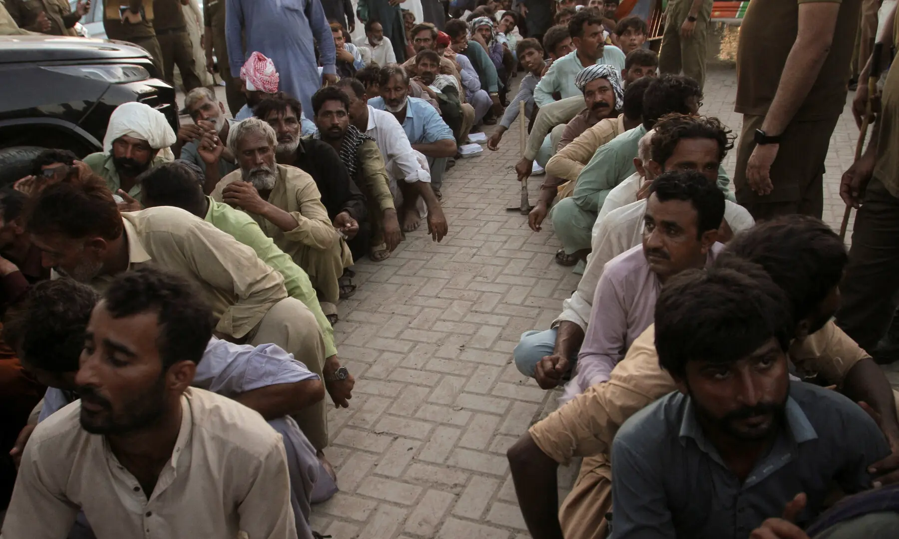 Flood victims sit as they receive food handouts, following monsoon rains and rising water levels of the Chenab River, in Alipur in Muzaffargarh District, Punjab on September 12, 2025. — Reuters
