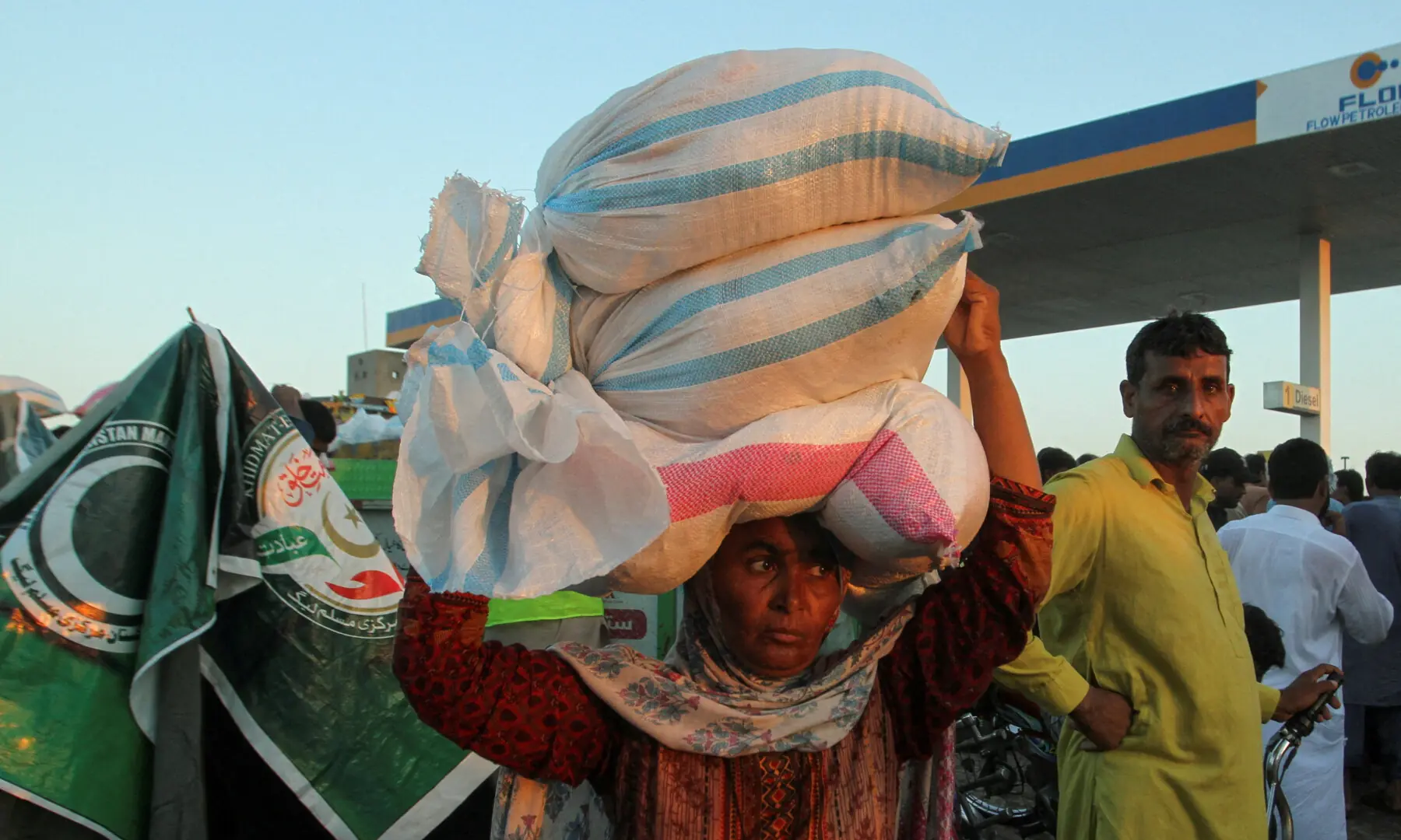 Zainab Bibi, a flood victim, carries sacks of handouts on her head, that she received from a distribution point, following monsoon rains and rising water levels of the Chenab River, in Alipur in Muzaffargarh District, Punjab on September 12, 2025. — Reuters