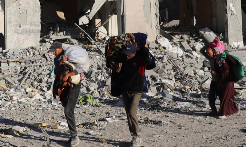 Palestinians carry their belongings as they walk through a damaged neighbourhood in the aftermath of an Israeli operation, after Israel&rsquo;s government ratified a ceasefire with Hamas, in Gaza City, on October 10, 2025. &mdash; Reuters