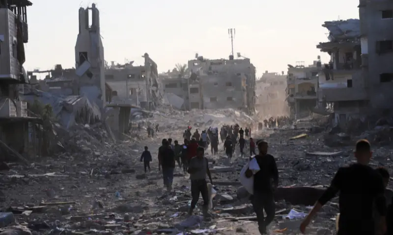 Palestinians walk through a damaged neighbourhood in the aftermath of an Israeli operation, after Israel&rsquo;s government ratified a ceasefire with Hamas, in Gaza City, on October 10, 2025. &mdash; Reuters