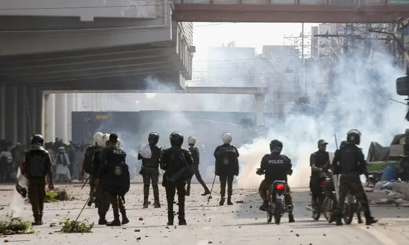 Police officers stand as they use tear gas to disperse supporters of Tehreek-e-Labbaik Pakistan (TLP) during a solidarity march for Gaza in Lahore on October 10. — AFP Police officers stand as they use tear gas to disperse supporters of Tehreek-e-Labbaik Pakistan (TLP) during a solidarity march for Gaza in Lahore on October 10. — AFP