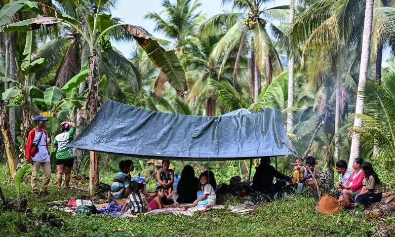 Residents gather at a makeshift tent outside their home in Manay, in the province of Davao Oriental on October 11, 2025, after two powerful quakes struck off the southern Philippines on October 10, killing at least eight people. &mdash;AFP