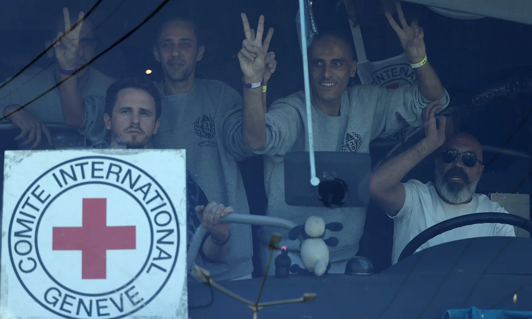 Palestinian men gesture from inside a bus after being released from the Ofer military prison located between Ramallah and Beitunia in the occupied West Bank on October 13, 2025, in exchange for hostages held by Hamas in Gaza since the October 7 attacks. — AFP