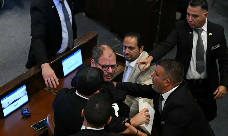  Israeli Knesset member Ofer Cassif is escorted out after holding a sign reading &ldquo;Recognise Palestine&rdquo; during a speech by US President Donald Trump at the Israeli parliament, the Knesset, in Jerusalem on Oct 13, 2025. &mdash; AFP 