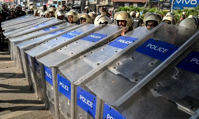 Riot policemen stand guard as activists of the Tehreek-e-Labbaik Pakistan (TLP) party gather near their party headquarters, as authorities blocked the road with shipping containers, in Lahore on October 9. — AFP Riot policemen stand guard as activists of the Tehreek-e-Labbaik Pakistan (TLP) party gather near their party headquarters, as authorities blocked the road with shipping containers, in Lahore on October 9. — AFP