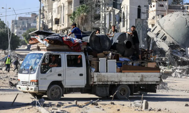 Palestinians ride on a truck loaded with belongings, amid a ceasefire between Israel and Hamas, in Gaza City, on October 16, 2025. &mdash; Reuters