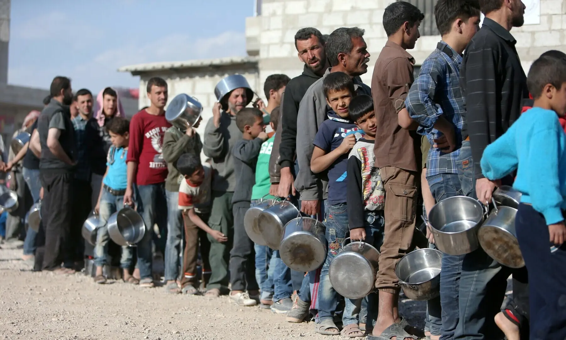 In this file photo, internally displaced Syrians from eastern Ghouta queue for food in Herjelleh shelter in Damascus countryside, Syria, April 15, 2018. &mdash; Reuters/File