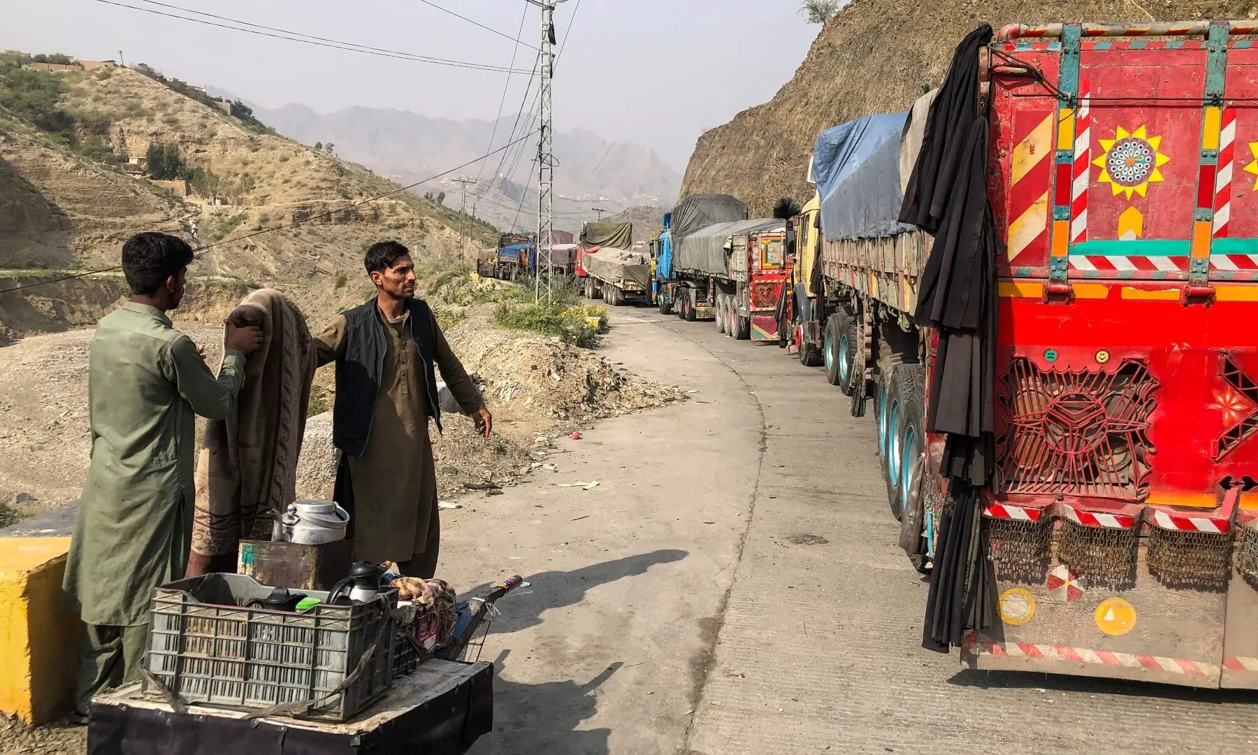  A tea vendor stands near the stalled vehicles near the closed Pakistan-Afghanistan border town of Torkham, Pakistan, October 19. &mdash; AFP 