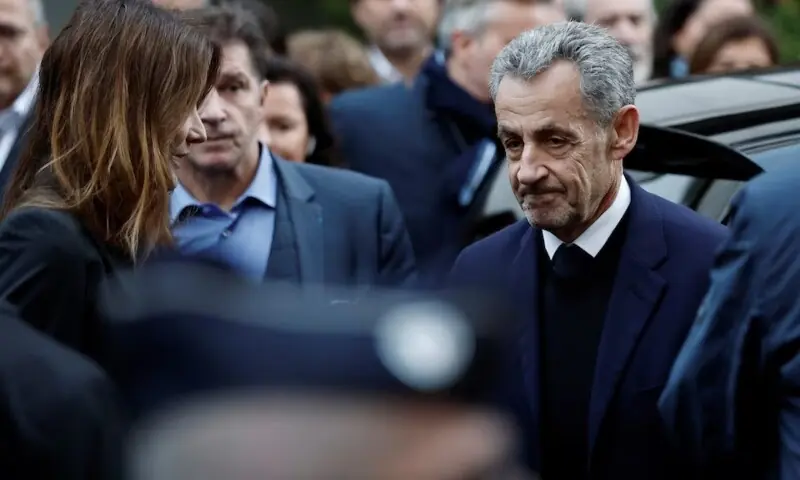 Former French president Nicolas Sarkozy stands next to his wife Carla Bruni-Sarkozy before leaving in a car on the day of his incarceration at the Sante prison to begin his five-year prison sentence for criminal conspiracy over attempts to raise campaign funds from Libya, in Paris, France, Oct 21. &mdash; Reuters