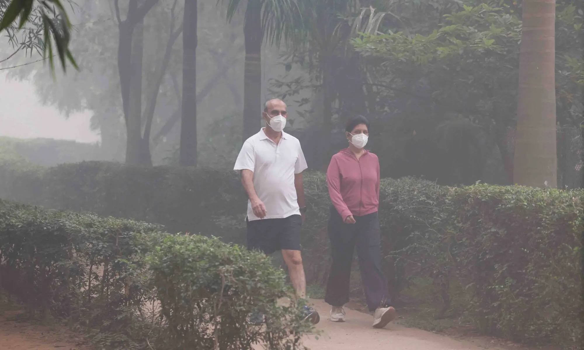 PEOPLE walk wearing face masks at a park in New Delhi amidst smog on the day after Diwali.&mdash;Reuters