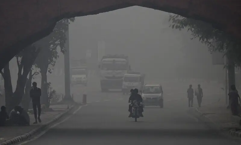 Commuters drive amid heavy smog in New Delhi on October 21. &mdash; AFP