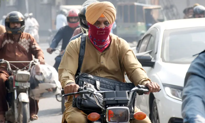 Motorcyclists cover their faces to protect themselves from smog. &mdash; Online