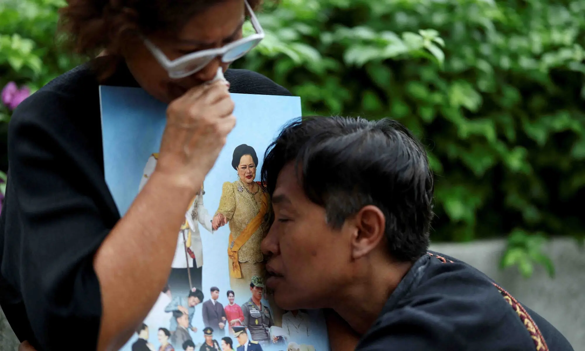 People react while holding a picture of Thailand&rsquo;s Queen Mother Sirikit, 93, following the announcement of her death, outside King Chulalongkorn Memorial Hospital in Bangkok, Thailand, October 25. &mdash; Reuters