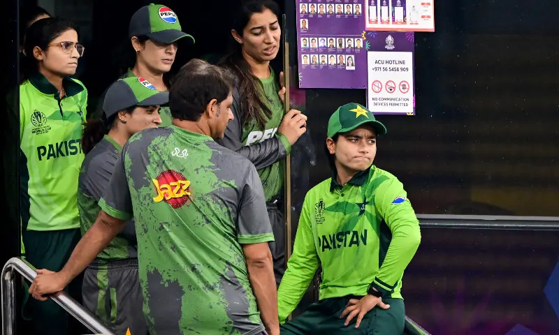 A distraught Pakistan&rsquo;s captain Fatima Sana (R), along with head coach Mohammad Waseem and teammates, stand near their dressing room as the toss gets delayed due to rain before the start of their final World Cup match against Sri Lanka at the R. Premadasa International Cricket Stadium in Colombo on October 24, 2025. &mdash; AFP