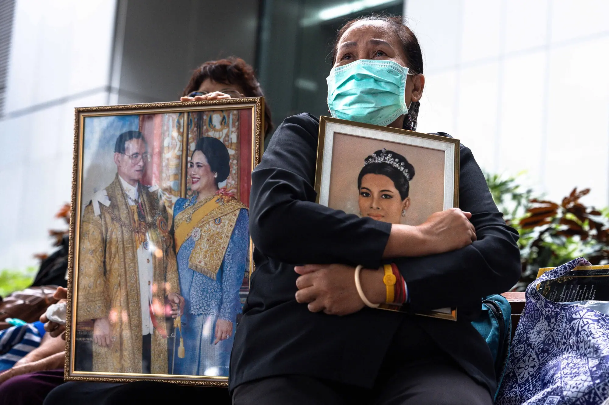     Thai mourner Pattamaporn Kaewpreyakorn (right) holds a portrait of Thailand's former queen Sirikit in front of Chulalongkorn hospital in Bangkok on October 25. —AFP 