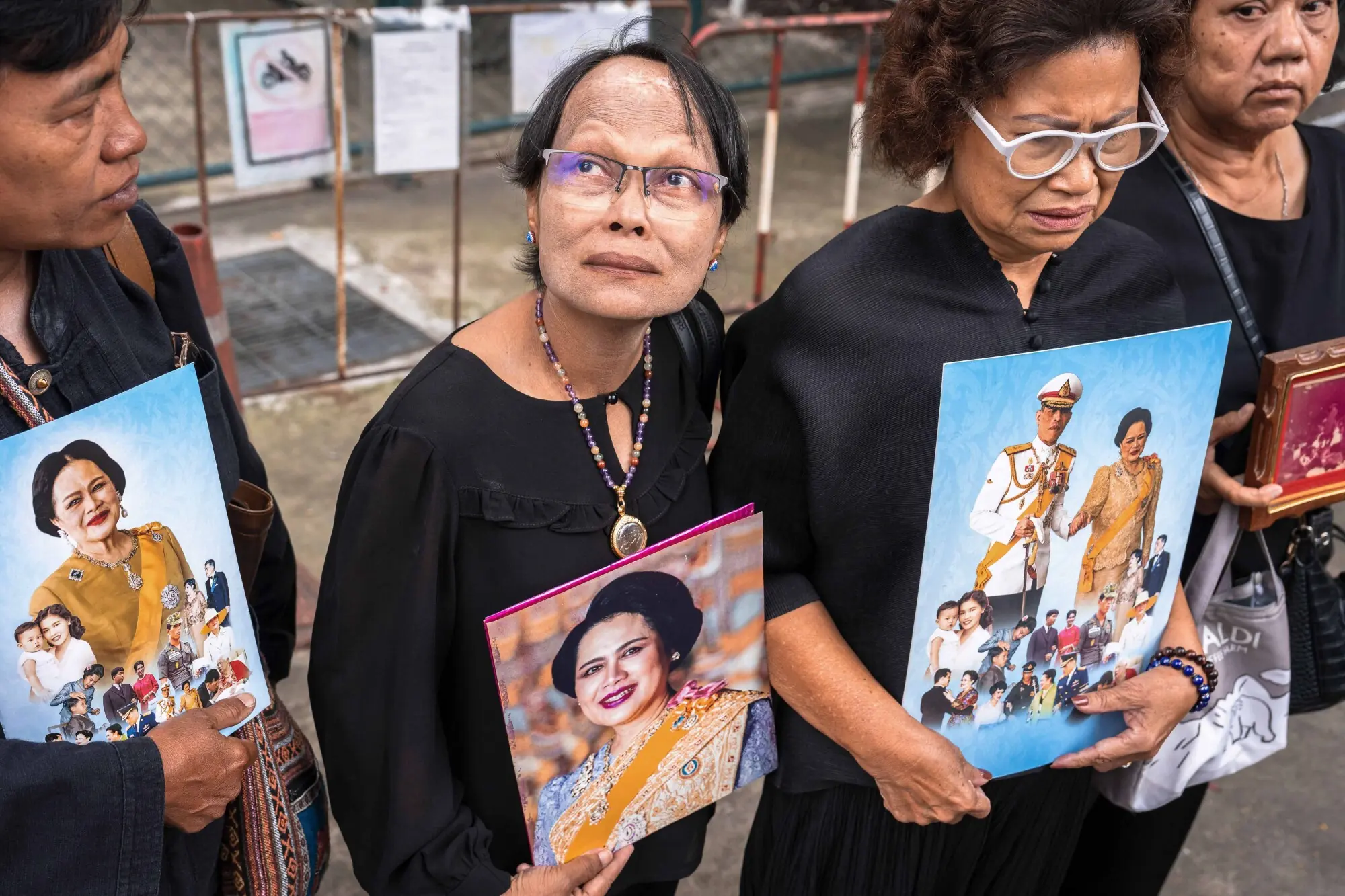     People hold portraits of Thailand's former Queen Sirikit as they gather outside Chulalongkorn Hospital, where she died, in Bangkok on October 25. — AFP 