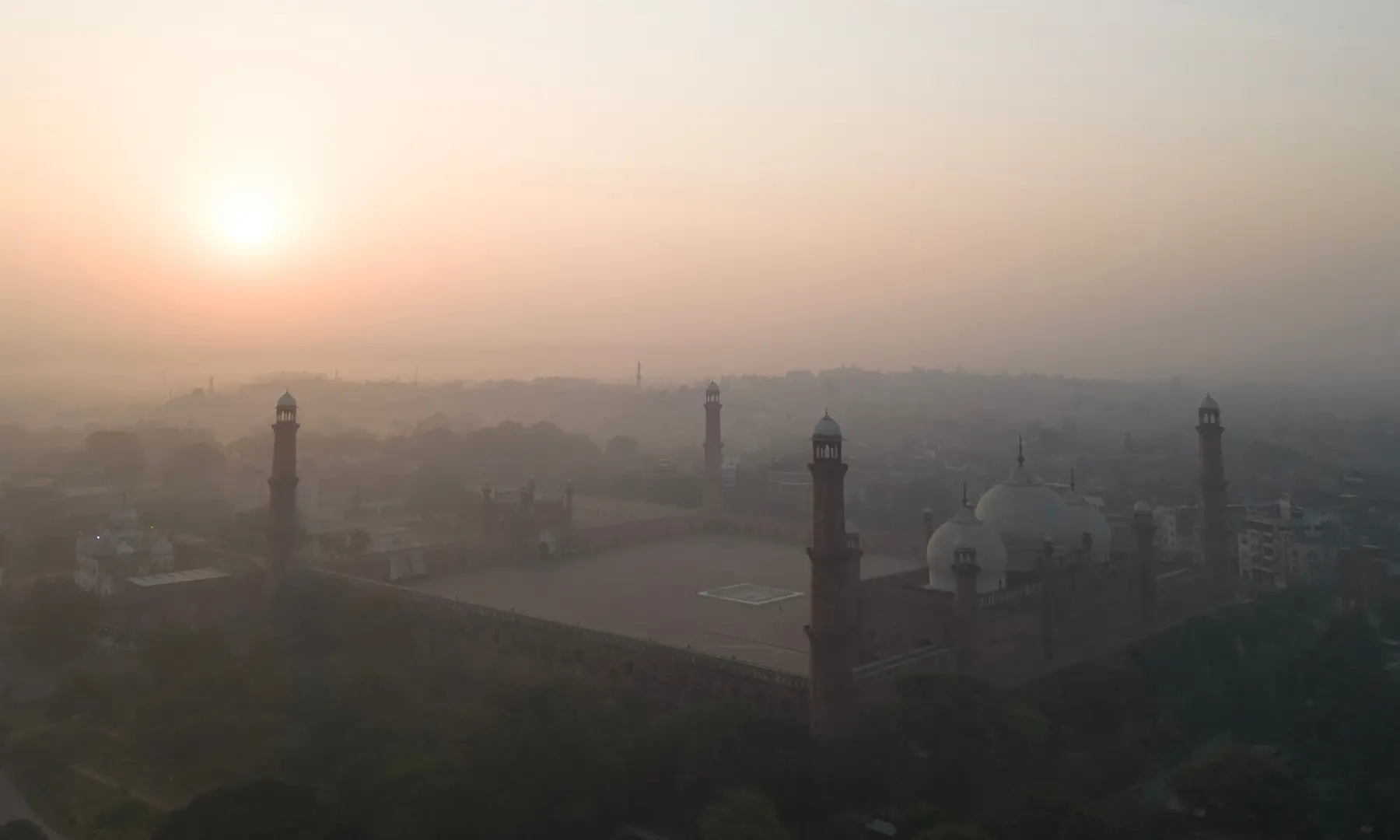 An aerial view shows the Badshahi Mosque shrouded in smog during sunrise in Lahore on October 25. — AFP