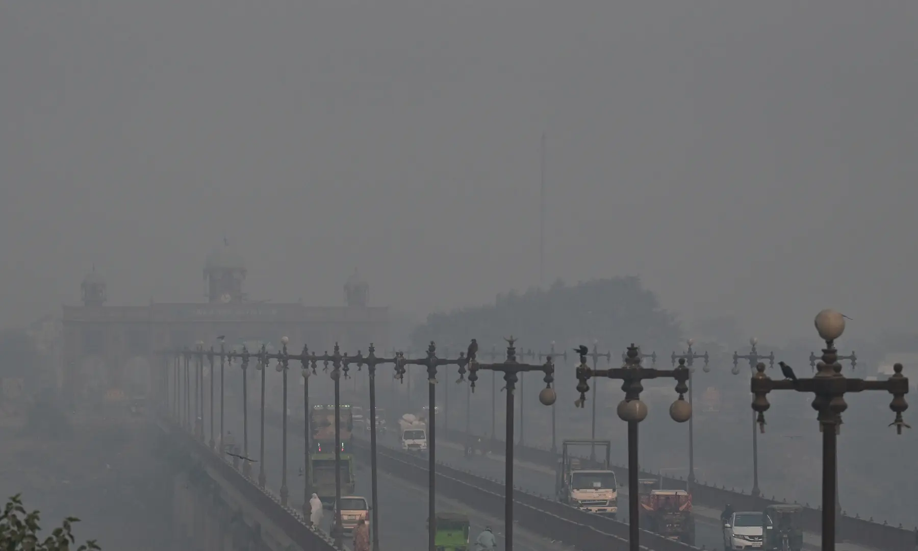 Commuters travel along a highway amid smoggy conditions in Lahore on October 24. — AFP