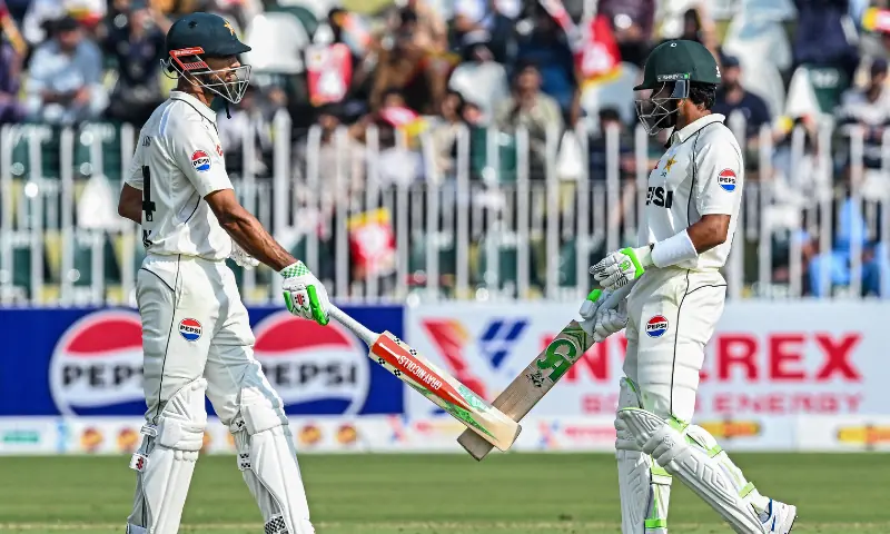 Pakistan&rsquo;s captain Shan Masood (L) and his teammate Babar Azam bump their bats during the first day of the second Test cricket match between Pakistan and South Africa at the Rawalpindi Cricket Stadium in Rawalpindi on October 20, 2025. &mdash; AFP