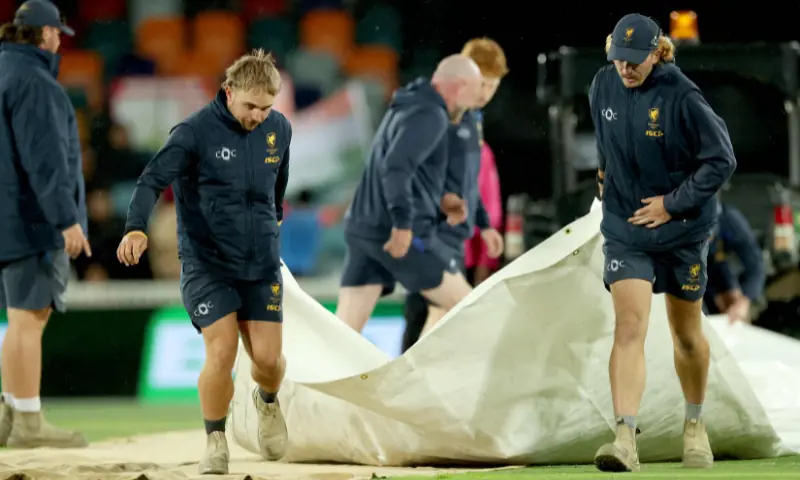 Ground staff bring on the covers as rain interrupts play during the first Twenty20 international cricket match between Australia and India at Manuka Oval in Canberra on October 29, 2025. &mdash; AFP