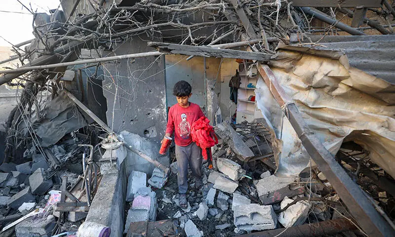 A child walks through the rubble of a house destroyed in an Israeli strike in Nuseirat, central Gaza Strip, on October 29. — AFP