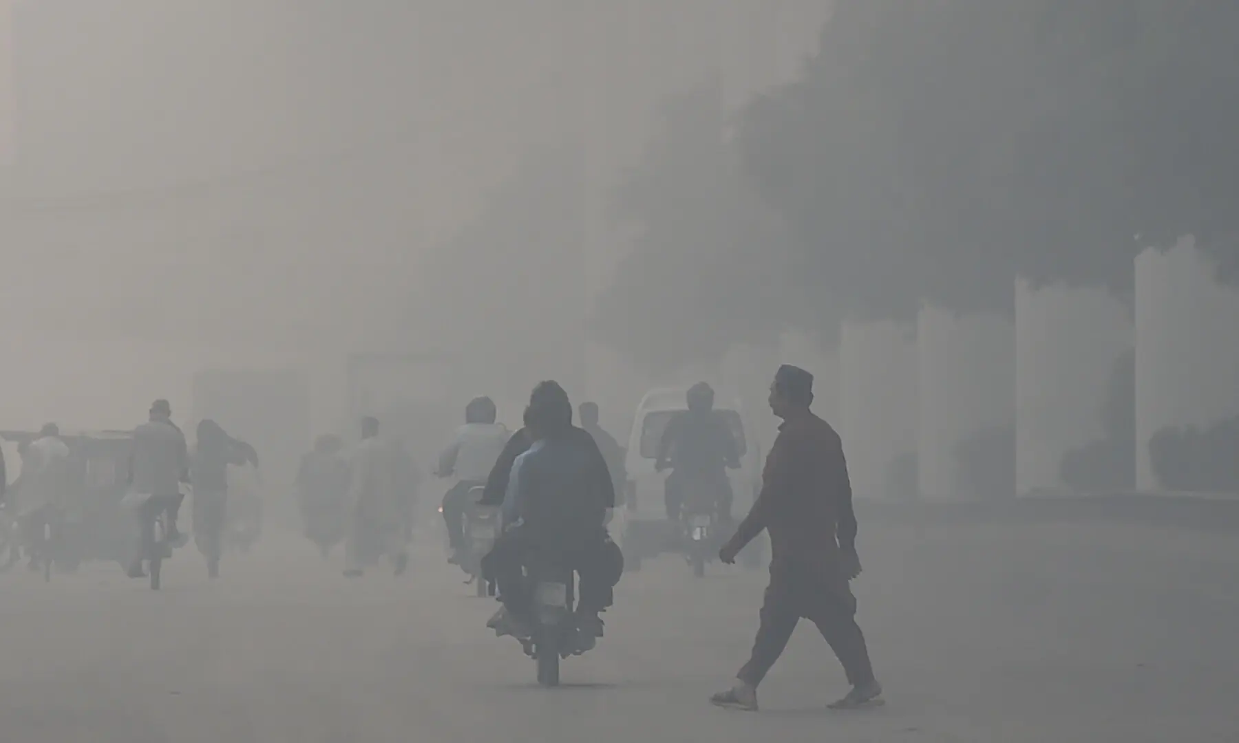 Commuters drive along a road amid dense smog in Lahore on Oct 29, 2025. &mdash; AFP