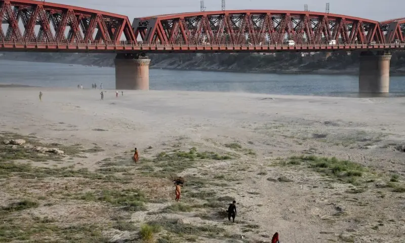 People walk on the dry riverbed of the Indus River in Hyderabad on April 24, 2025. &mdash; Reuters