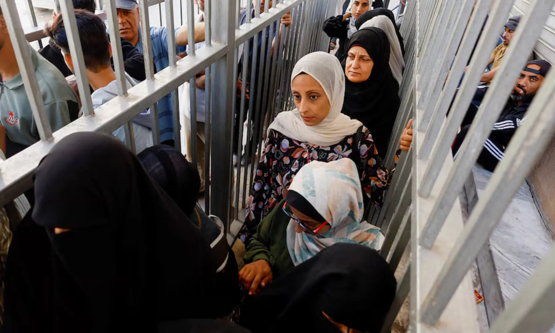 Palestinian women queue outside the Bank of Palestine amid a cash shortage, in Nuseirat, in the central Gaza Strip on October 27, 2025. &mdash; Reuters