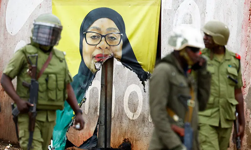 Tanzanian riot police officers walk past a vandalised campaign poster of President Samia Suluhu Hassan, following a protest a day after a general election marred by violent demonstrations at the Namanga One-Post Border crossing point between Kenya and Tanzania, October 30. — Reuters Tanzanian riot police officers walk past a vandalised campaign poster of President Samia Suluhu Hassan, following a protest a day after a general election marred by violent demonstrations at the Namanga One-Post Border crossing point between Kenya and Tanzania, October 30. — Reuters