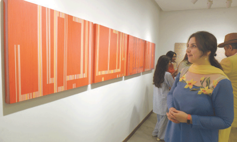 Visitors view paintings at the exhibition held at Tanzara Gallery in Islamabad on Thursday. — White Star