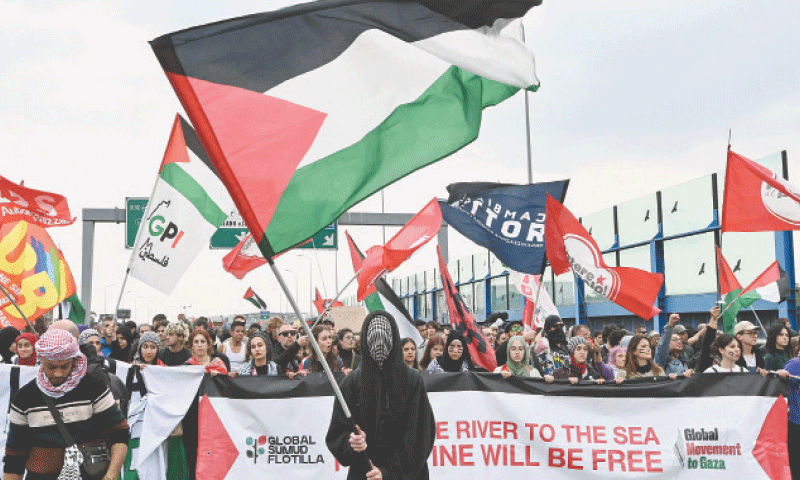 MILAN: Demonstrators wave Palestinian flags during a protest on a highway, against the interception of the Global Sumud Flotilla by the Israeli army.&mdash;AFP