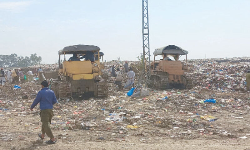 Heavy machinery being used to remove garbage, but it again resurfaces within days. &mdash; Dawn