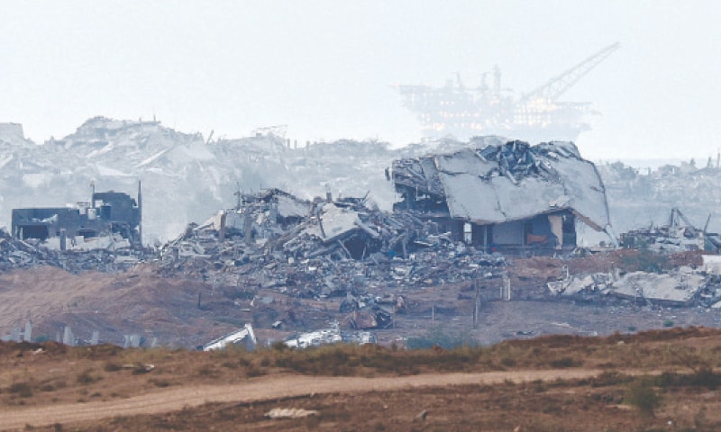 Destroyed buildings in Gaza, with an oil rig in the distance, after Israeli strikes.&mdash;Reuters
