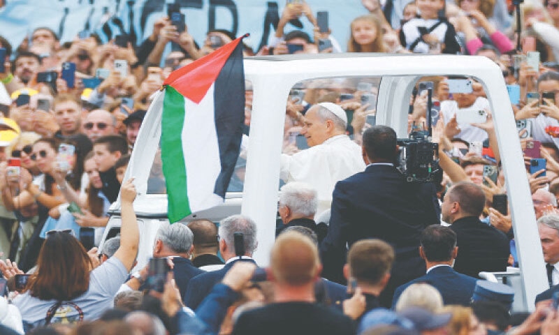 Vatican City: A person waves a Palestinian flag as Pope Leo XIV greets faithful on the day of the Mass for the Jubilee of the Missionary World and Jubilee of Migrants in St. Peter’s Square on Sunday.—Reuters Vatican City: A person waves a Palestinian flag as Pope Leo XIV greets faithful on the day of the Mass for the Jubilee of the Missionary World and Jubilee of Migrants in St. Peter’s Square on Sunday.—Reuters