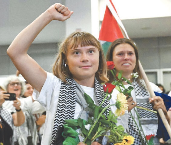 Swedish activist Greta Thunberg raises her fist after arriving at Athens airport.&mdash;AFP