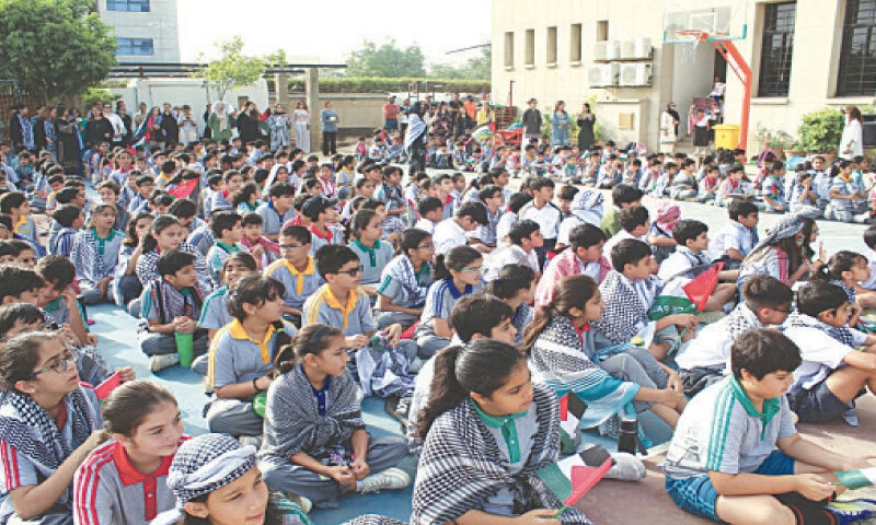 Students wear keffiyeh in a sign of solidarity with the Palestinian cause.&mdash;Dawn