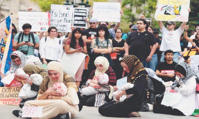 GUADALAJARA (Mexico): Women perform a piece about children killed in Gaza during a demonstration demanding an end to Israeli attacks.—AFP GUADALAJARA (Mexico): Women perform a piece about children killed in Gaza during a demonstration demanding an end to Israeli attacks.—AFP