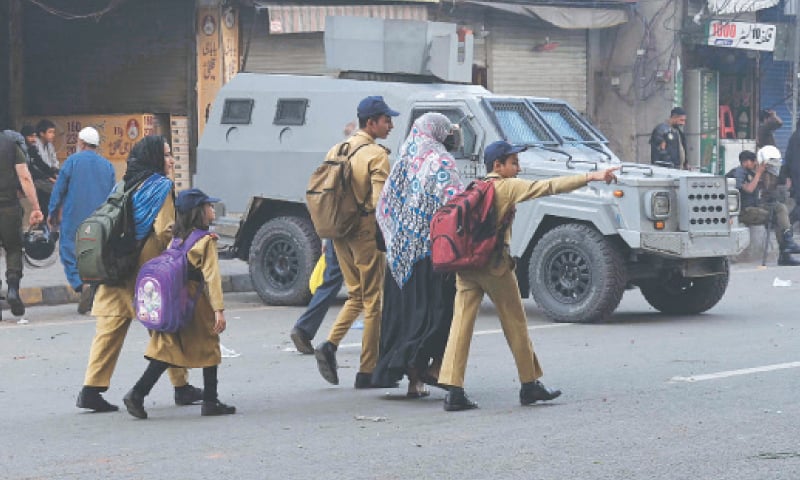 Children on the way to school on foot due to a road blockade at Yateem Khana Chowk after a clash between police and TLP activists. &mdash; White Star