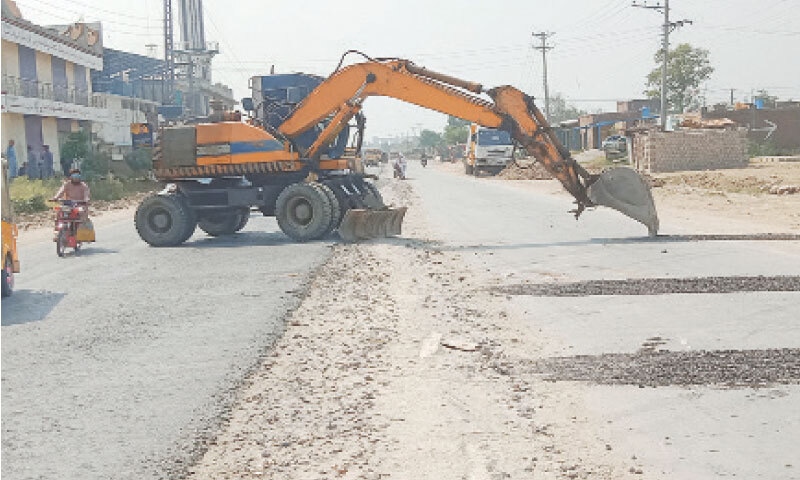 An excavator digs the Swabi-Jehangira Road near Shahmansoor village for reconstruction. &mdash; Dawn