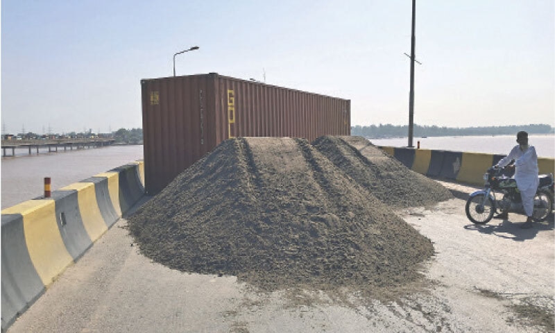 A container is placed on the Chenab River bridge connecting Gujrat and Wazirabad on Saturday.—Dawn