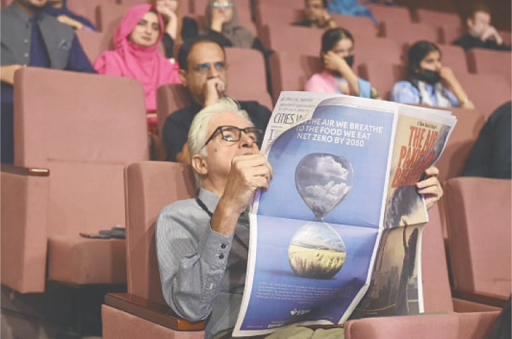 A participant reads The Air Pakistan Breathes supplement. &mdash; White Star / Murtaza Ali