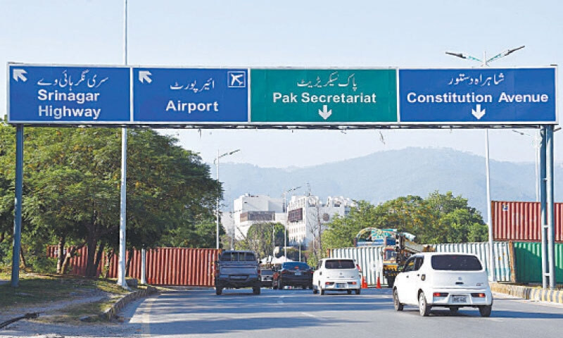 Traffic moves on Club Road in Islamabad as containers partially removed on Sunday. &mdash; Photo by Mohammad Asim
