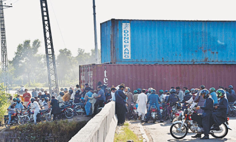 Pedestrians and motorcyclists find a narrow space to cross a bridge on Murree Road in Islamabad on Sunday. &mdash; White Star