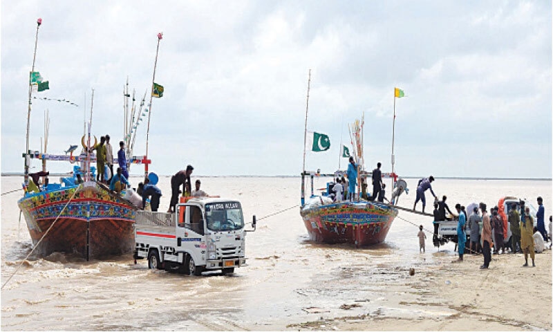 FISHERMEN unload their catch after returning from a week-long fishing trip in the Arabian Sea, at the Dando Jetty in Keti Bander.&mdash;Photo by Umair Ali