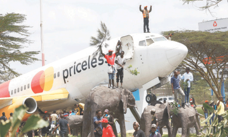 MOURNERS stand on a grounded aeroplane and elephant sculptures after arrival of the body of former Kenyan prime minister Raila Odinga from India.&mdash;Reuters