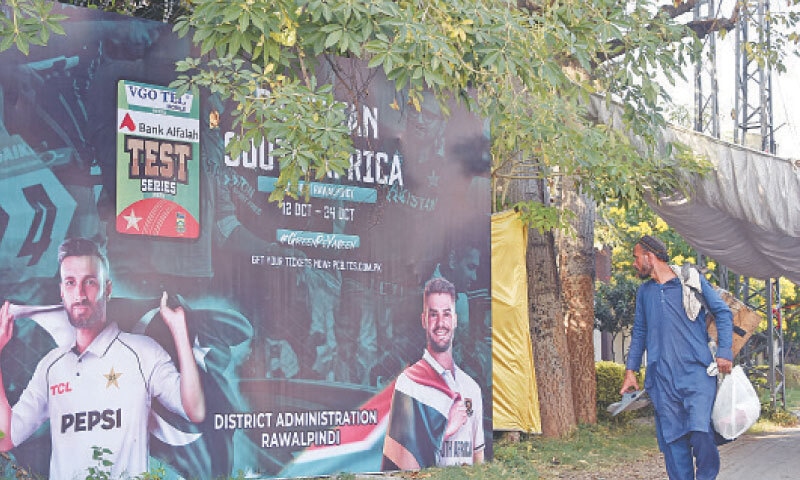 A man walks past a billboard of Pakistan and South African cricket captains installed along Murree Road in Rawalpindi on Sunday. The second test match between the two teams will be played today at Rawalpindi Cricket Stadium. &mdash; Online