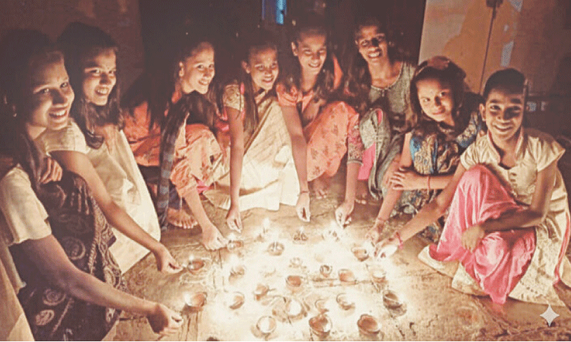 Girls light earthen lamps at Valmiki Temple in Attock during Diwali celebrations on Monday. &mdash; Dawn