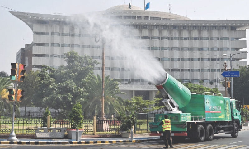 LAHORE: Workers from the Environmental Protection Agency operate an anti-smog gun on The Mall, as smog began to manifest across parts of Punjab. — M. Arif / White Star