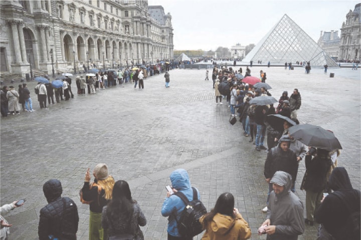 VISITORS queue in the Louvre pyramid courtyard moments before an announcement that the museum will remain closed for a second day running.&mdash;AFP