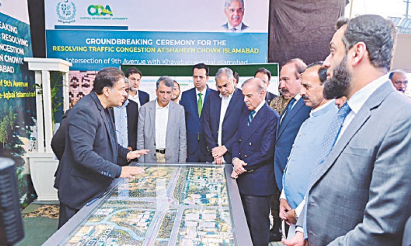 Prime Minister Shehbaz Sharif is being briefed about the Shaheen Chowk Interchange project in Islamabad on Friday. &mdash; Photo by Mohammad Asim